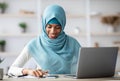 Remote Entrepreneurship. Black Islamic Businesslady Using Smartphone While Working At Home Office Royalty Free Stock Photo