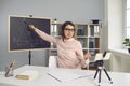 Young college or school teacher giving online lesson, using smartphone with tripod Royalty Free Stock Photo