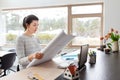 Young woman with blueprint working at home office Royalty Free Stock Photo