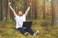 Remote job - man with laptop enjoying working outdoors. hands raised Royalty Free Stock Photo