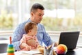 Father with baby working on laptop at home office Royalty Free Stock Photo