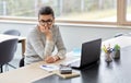 Bored woman with laptop working at home office