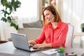 Woman with headset and laptop working at home Royalty Free Stock Photo