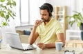 Indian man with headset and laptop working at home Royalty Free Stock Photo