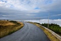 Remote mountain service road with clouds