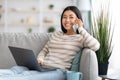 Remote Office. Cheerful Young Asian Woman Using Cellphone And Laptop At Home Royalty Free Stock Photo