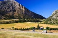 Remote rural valley with crop field and mountain face under blue sky - Sierra Nevada Royalty Free Stock Photo