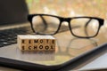 REMOTE SCHOOL virtual learning concept with wood block letters on laptop Royalty Free Stock Photo