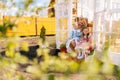 Remote view of cheerful blonde young mother in dress sitting on doorstep of summer gazebo house with two little adorable Royalty Free Stock Photo