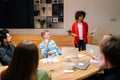 Remote view of diverse business team in boardroom listening to female African American manager making report about Royalty Free Stock Photo