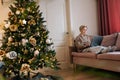 Remote view of focused elegant middle-aged woman remote working or shopping online buying new year presents sitting on Royalty Free Stock Photo