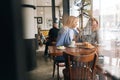 Remote view of frustrated young woman and best female friend trying to comfort and cheer up sitting together in cafe Royalty Free Stock Photo
