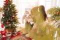 Remote view of happy family wearing winter clothes sitting in decorated room of summer house on Christmas eve. Young Royalty Free Stock Photo