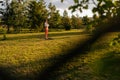 Remote wide shot of peaceful woman raising hands in Namaste pose standing on yoga mat during sunset. Beautiful lady Royalty Free Stock Photo