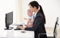 Remote work, businesswoman with her baby and typing on keyboard with pc at her desk in a office. Technology, commitment Royalty Free Stock Photo