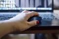 Remote work. Close-up of a female hand holding a computer mouse Royalty Free Stock Photo