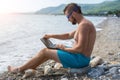 Remote work concept: Business man working on a laptop while relaxing on the beach Royalty Free Stock Photo