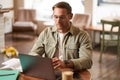 Remote work and freelance concept. Handsome man in glasses sits with notebook and laptop, studying online, working Royalty Free Stock Photo
