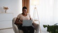Young chubby african american woman networking on laptop, chatting with clients or partners, working from home Royalty Free Stock Photo