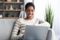 Remote Work. Smiling Black Freelancer Lady Using Laptop While Sitting On Couch Royalty Free Stock Photo