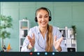 Remote work and technology. Happy woman wearing headphones while having video conference