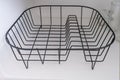 Removable empty steel dish dryer rack in a kitchen cupboard, modern convenient useful equipment for drying tableware and