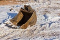 Removable excavator bucket against the background of white snow. Crawler excavator bucket Royalty Free Stock Photo