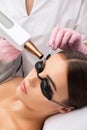 Removal of permanent makeup on the eyebrows of a woman.Carbon face peeling in a beauty salon. Hardware cosmetology treatment Royalty Free Stock Photo