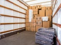 Removal van interior, stacked boxes and blankets. Copy space.