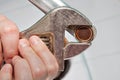 Remove old aerator from tap with an adjustable spanner, closeup.