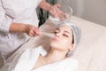 Remove with spatula foam from the face. Young pretty woman receiving treatments in beauty salons. Facial cleansing foam