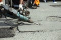 He removes the asphalt with a jackhammer. Removing the asphalt layer from the road