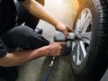 Removing car mechanic to repair the leaky tire car wheels.Mechanic changing a car tire on a vehicle a hoist using an electric dril Royalty Free Stock Photo