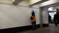 Removing graffiti and paint from vandals. an employee of the city, wearing a orange uniform, cleans the wall from