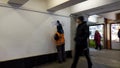 Removing graffiti and paint from vandals. an employee of the city, wearing a orange uniform, cleans the wall from