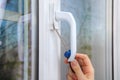 Removing handle of a plastic window using hand screwdriver.