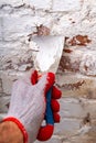 Removing mildew from the brick wall with a metal spatula. Small painting works at home Royalty Free Stock Photo