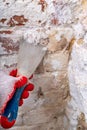 Removing mildew from the brick wall with a metal spatula. Small painting works at home Royalty Free Stock Photo