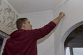 Removing off old wallpaper from the wall with a spatula. Preparing for renovation of the room. Royalty Free Stock Photo