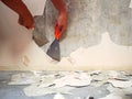 Removing old paint from the old wall by hand with a metal spatula. Painting Preparation at home Royalty Free Stock Photo