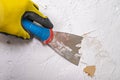 Removing old paint from the wall with a metal spatula. Small painting works at home Royalty Free Stock Photo