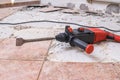 Removing old tiles. Jackhammer - drilling demolition hammer on floor Royalty Free Stock Photo