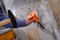 Removing old tiles from the wall in the kitchen using a chisel with a special plastic nozzle for safety when hammering Royalty Free Stock Photo