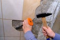 Removing old tiles from the wall in the kitchen using a chisel with a special plastic nozzle for safety when hammering Royalty Free Stock Photo