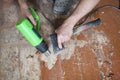 Removing paint color from an old wooden floor. Repair process with man`s hands Royalty Free Stock Photo
