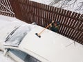 Removing snow pile from a car top Royalty Free Stock Photo