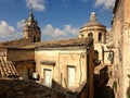 A renaissance epoch chapel seen through the old fashioned tile roofs in Modica