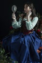 A Renaissance or Fantasy/fairytale/gypsy woman wearing a red brocade corset and blue silk skirt Royalty Free Stock Photo