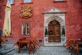 Renaissance historical red house where the alchemist lived. Brown old elegant front wooden carved door with a decorative flower