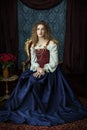 A Renaissance woman wearing a red brocade corset and blue silk skirt Royalty Free Stock Photo